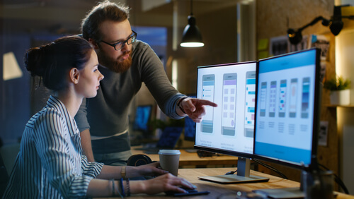 a woman and a man work at the computer Software localization skrivanek