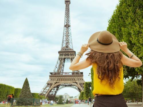 Touristin in Paris mit Blick auf den Eiffelturm Hallo auf Franzosisch skrivanek