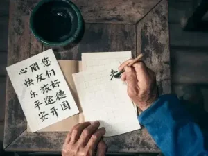 Person übt chinesische Kalligraphie mit Pinsel und Tinte auf Papier hallo auf chinesisch Übersetzungsbüro Berlin Person ubt chinesische Kalligraphie mit Pinsel und Tinte auf Papier hallo auf chinesisch Ubersetzungsburo Berlin