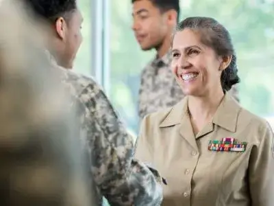 Lachelnde Soldatin im Gesprach mit Kameraden in Tarnuniform Ubersetzungsburo Berlin