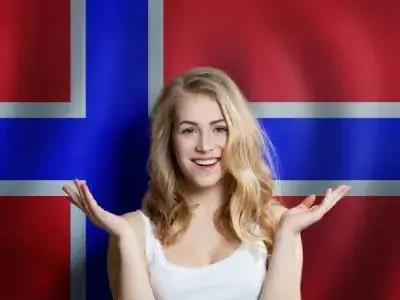 Frohliche junge Frau vor der norwegischen Flagge Auswandern nach Norwegen Ubersetzungsburo Berlin Skrivanek