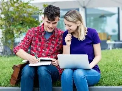 Two students studying outdoors and researching the easiest languages to learn for German speakers Übersetzungsbüro Berlin Skrivanek