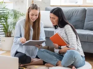 Two women studying together and discussing the easiest languages to learn for German speakers Ubersetzugnsburo Berlin